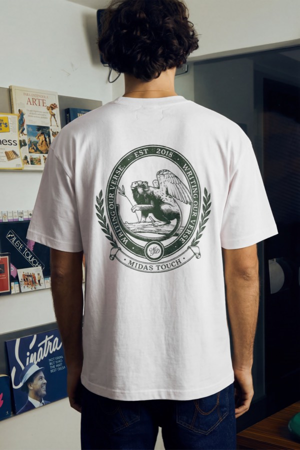 Camiseta branca com brasão “Midas Touch, Est. 2018” estampado nas costas